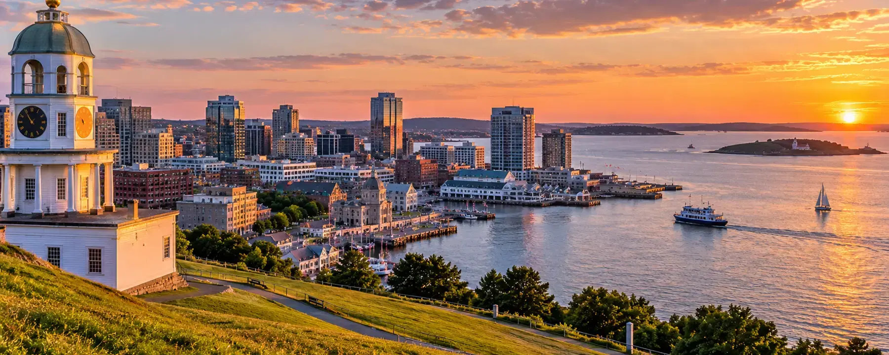 An Atlantic harbour at sunset, with a passenger ferry crossing and an island beyond.